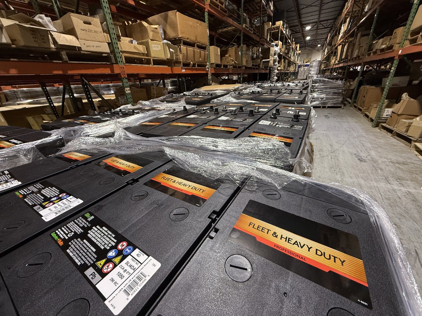 Pallets of shrink-wrapped fleet and heavy-duty batteries staged in the Drive Line warehouse
